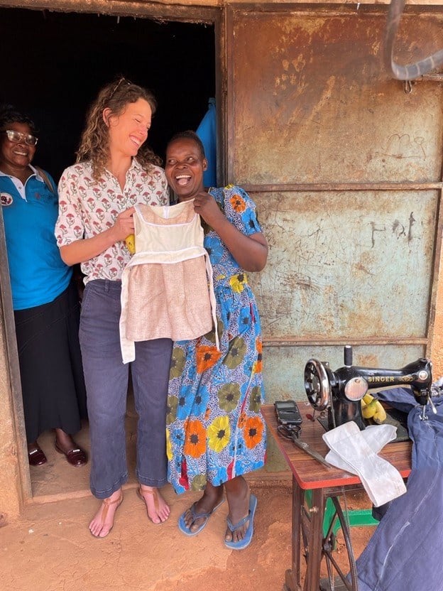 Fistula Foundation team members and a WADADIA outreach worker stand alongside Caroline, a fistula survivor, outside of her home in Kenya.