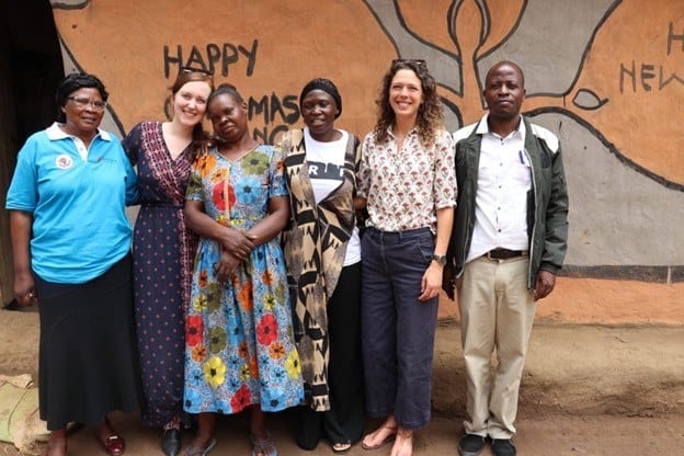 Fistula Foundation team members and a WADADIA outreach worker stand alongside Caroline, a fistula survivor, outside of her home in Kenya.