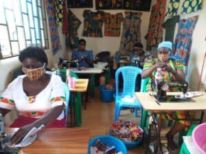 Women in Kenya sew face masks in a tailoring shop.