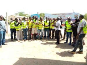 Men in yellow vests (boda boda riders) receive information about fistula.