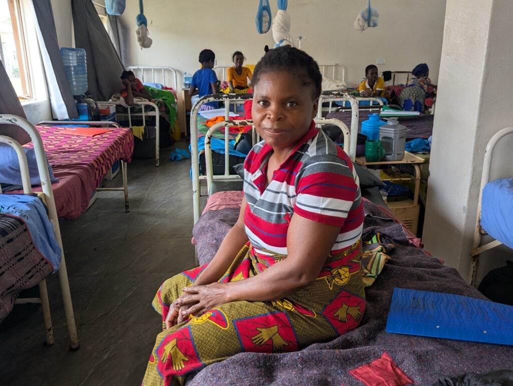 Priscah, a fistula survivor, sits on her hospital bed, thankful for the surgery that changed her life.