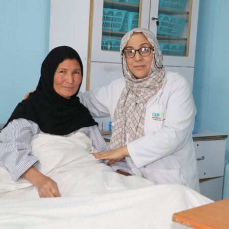 A patient in Afghanistan poses happily with a surgeon from Cure Hospital post-surgery