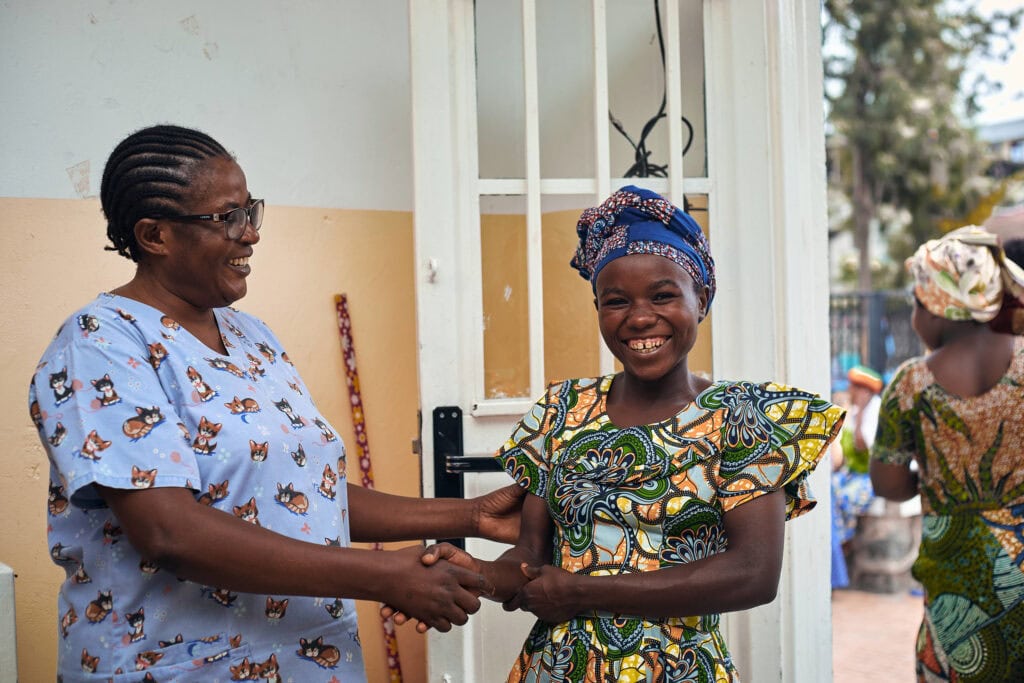 A nurse holds the hand and body of a fistula patient in a hospital