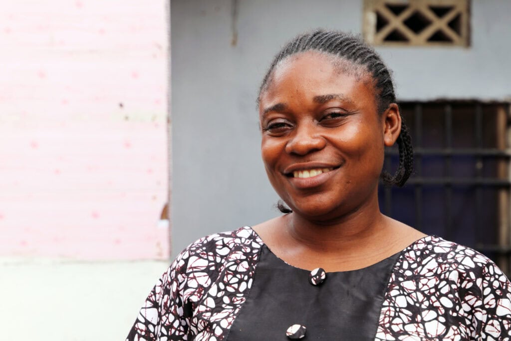 A smiling woman wearing a black and white dress